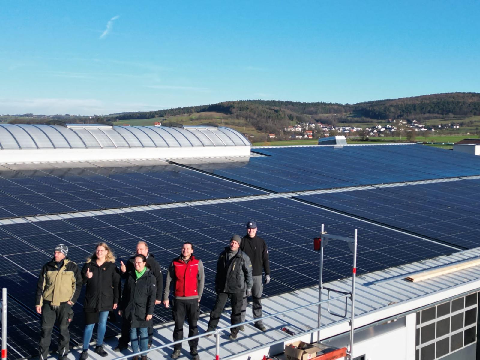 Gruppe Menschen vor PV-Anlagen